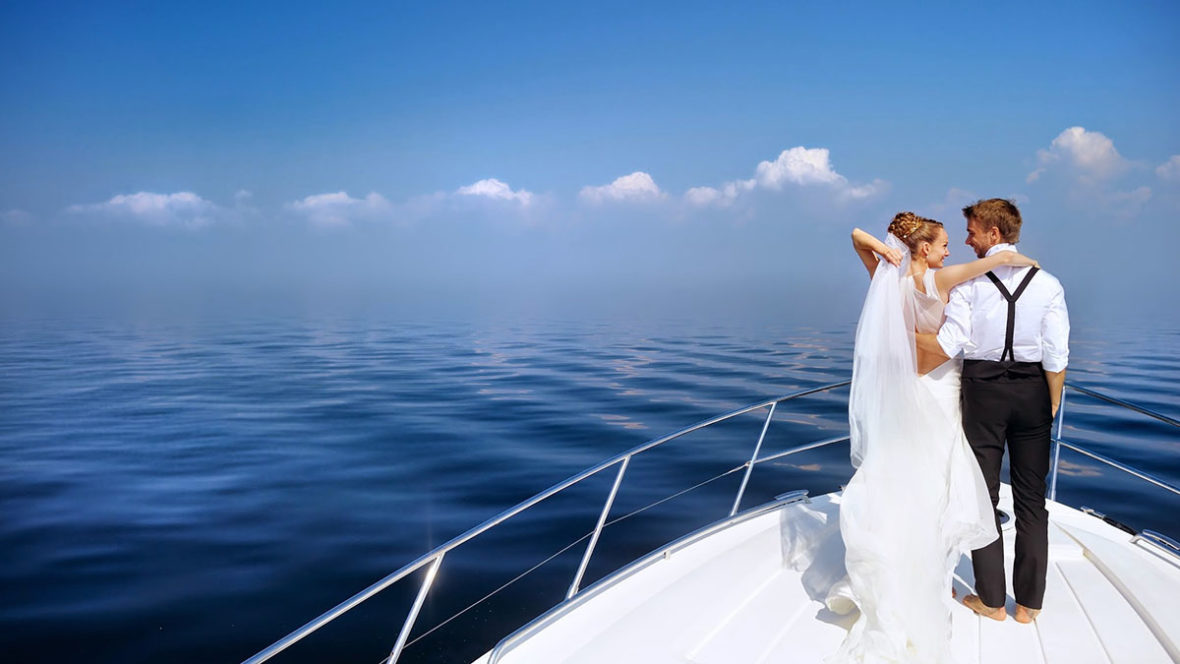 Happy bride and groom hugging on a yacht